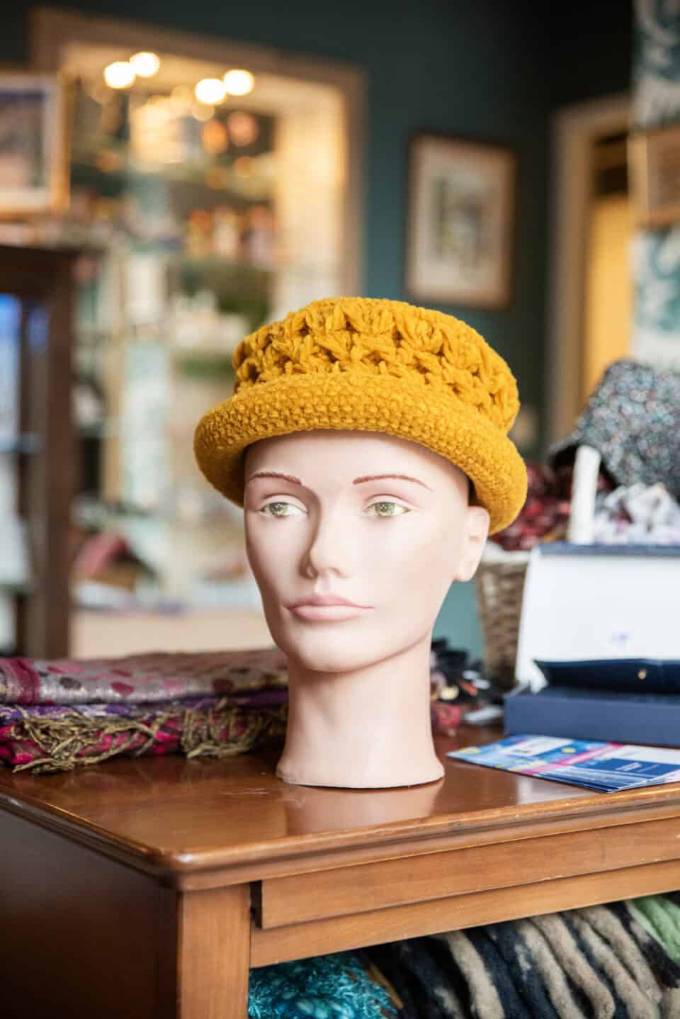 Chapeau tricoté jaune sur mannequin, boutique Emmaüs Cahors, seconde main.