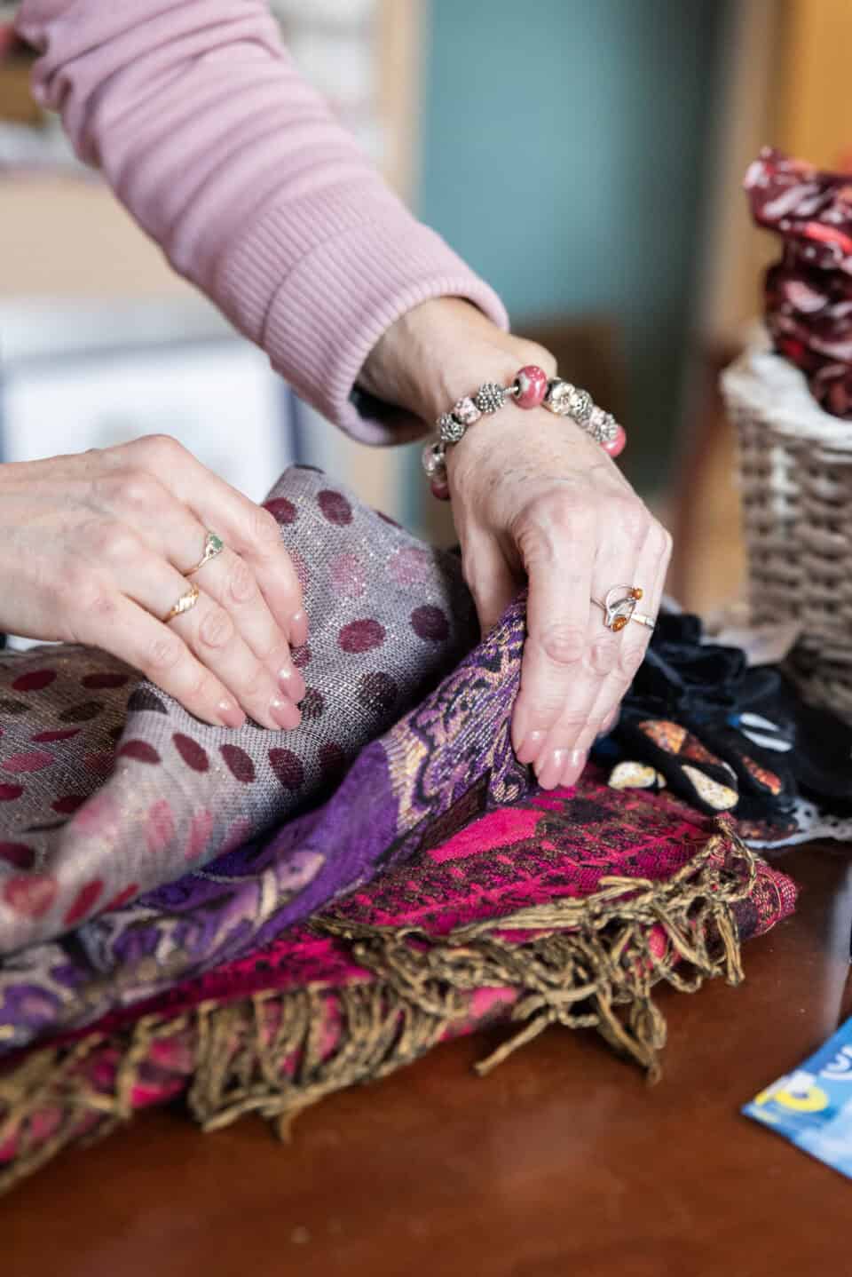 Paniers de vêtements et accessoires dans un magasin Emmaüs à Cahors.